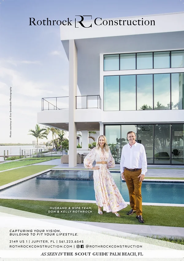 Kelly and Don Rothrock in front of modern-style luxury home with in-ground pool and lawn.