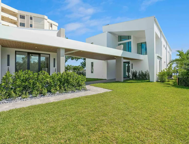 Exterior view of a white luxury modern home with large lawn