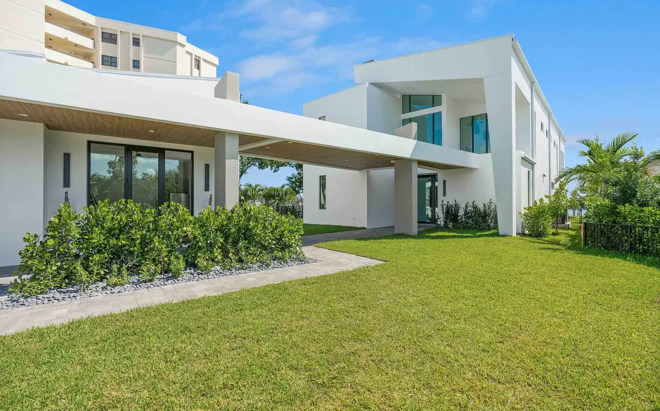 Exterior view of a white luxury modern home with large lawn