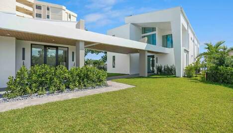 Exterior view of a white luxury modern home with large lawn