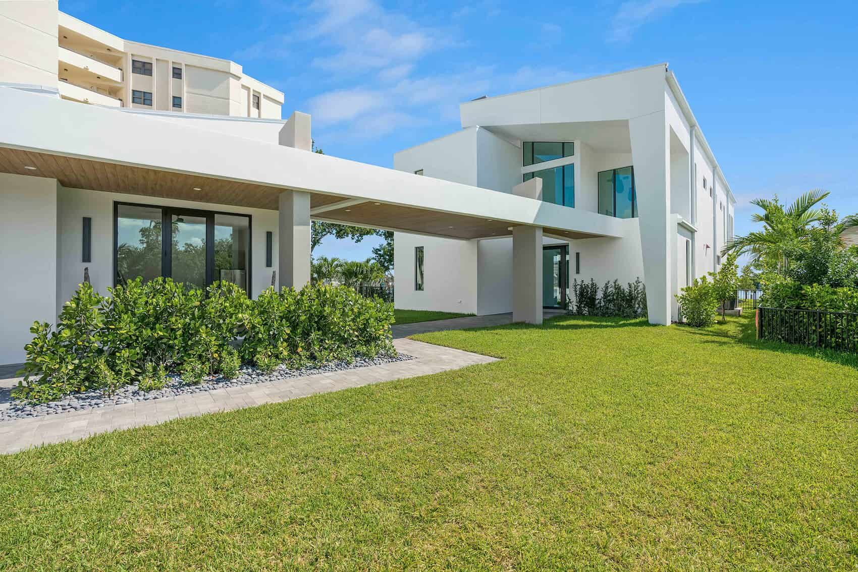 Exterior view of a white luxury modern home with large lawn