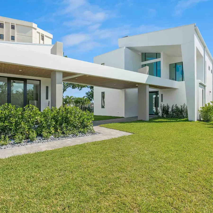 Exterior view of a white luxury modern home with large lawn