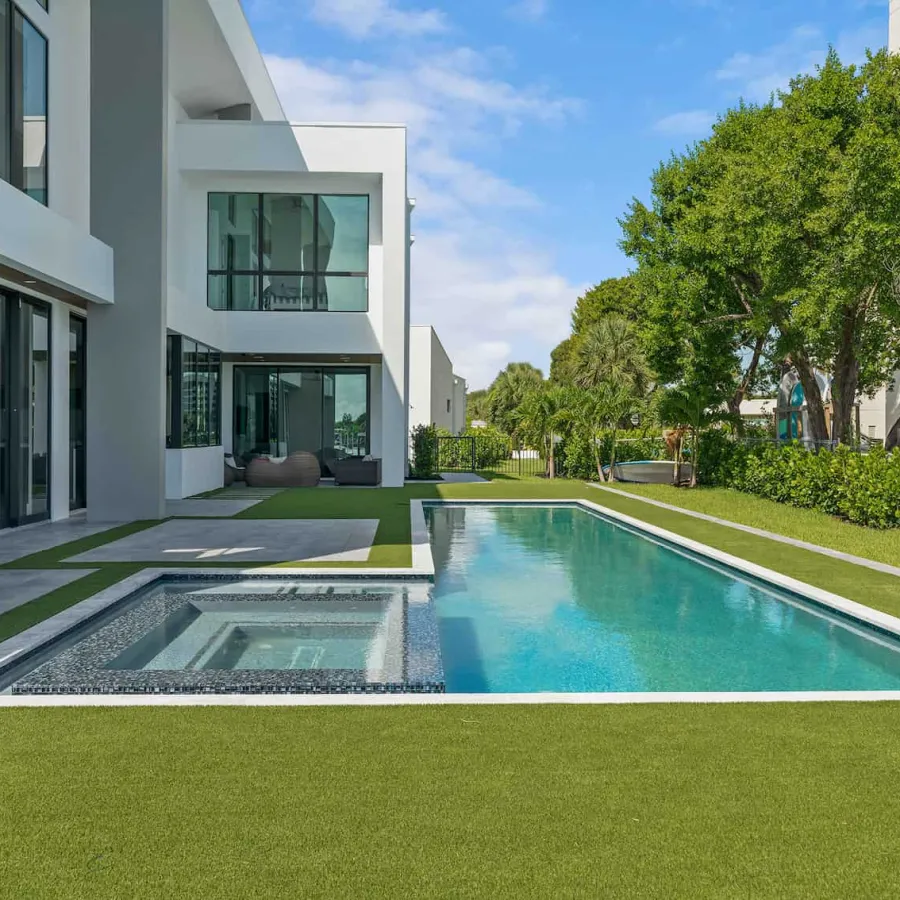 In-ground pool and lawn in the backyard of a luxury modern home.