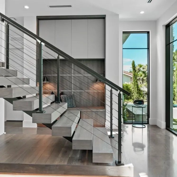 The front entry of a white modern house, glass doors and large stairs.