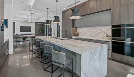 A large white house with a modern style and a well kept backyard.