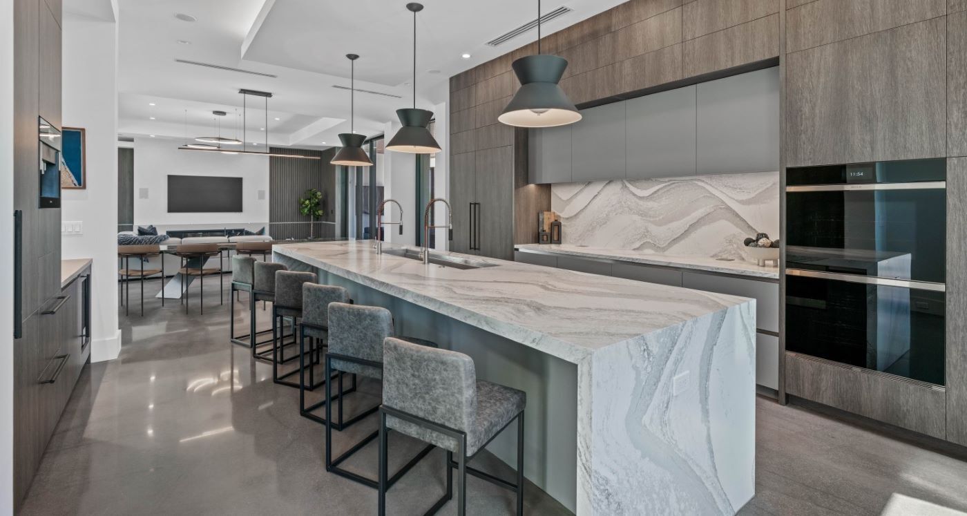 A large white house with a modern style and a well kept backyard.