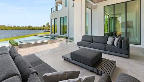 A large outdoor patio with a pool and large windows.