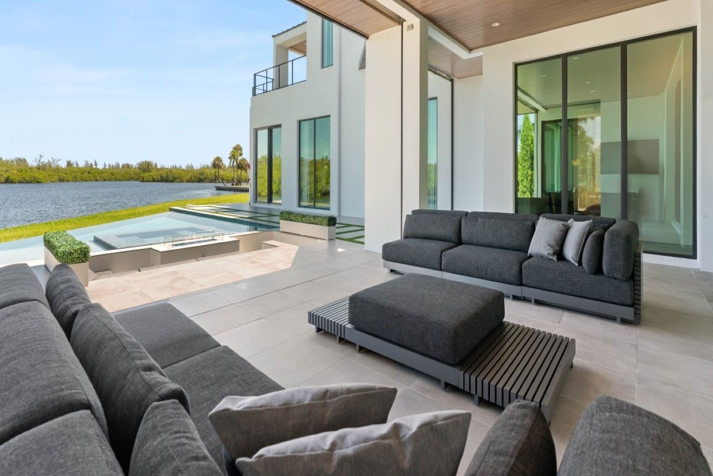 A large outdoor patio with a pool and large windows.