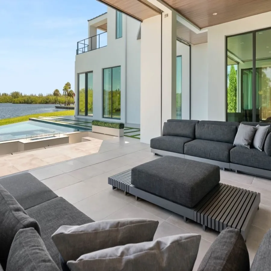 A large outdoor patio with a pool and large windows.