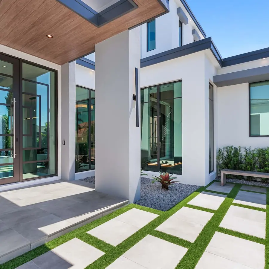 The front porch of a white modern house, glass doors and large windows.