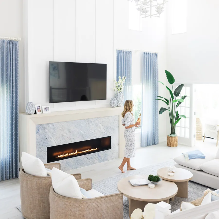 Modern living room with marble fireplace and soft textures.